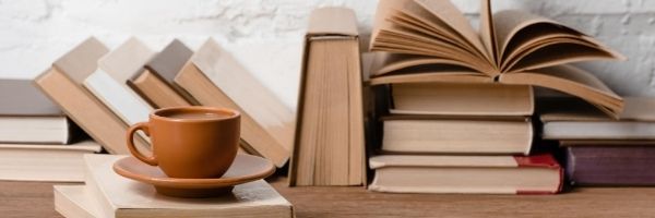 livros empilhados e uma xícara de café